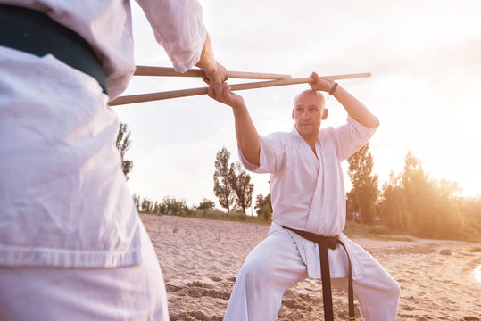 Two karatist fighting on sunset beach