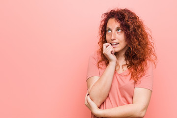 Young natural and authentic redhead woman relaxed thinking about something looking at a copy space.