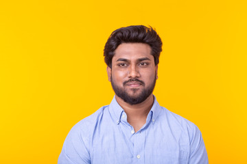 Indian handsome man wearing blue shirt on yellow background