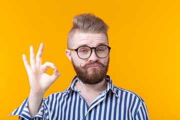 Positive funny hipster shirtless guy with a rocker collar shows ok on a yellow background. Concept...