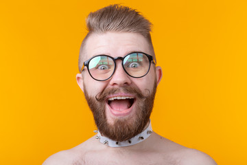 Crazy young hipster man with a mustache and beard joyfully opens his mouth on a yellow background. Concept of surprise and celebration.