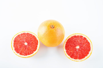 Fresh grapefruit and cut red flesh on white background