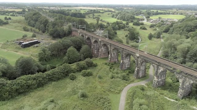 Sankey viaduct aerial above historical British railway arched bridge crossing. Aerial dolly right.
