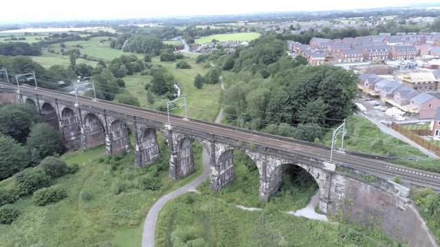 Sankey viaduct aerial above historical British railway arched bridge crossing. Aerial orbit left.