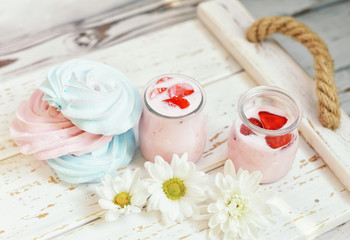 Fruit homemade yogurt and sweet cookies on a light wooden tray. The mood of summer holidays, eating on the air.