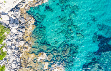 Aerial view of beautiful seashore in summer. Rocky beach and green islands seen from above.