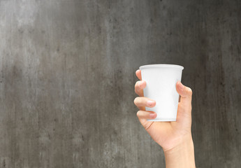 Hand holding a styrofoam cup with coffee