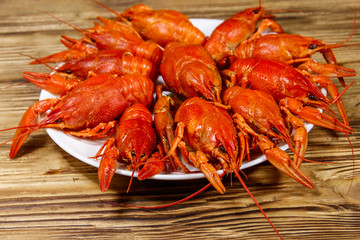 Boiled crayfish in plate on wooden table