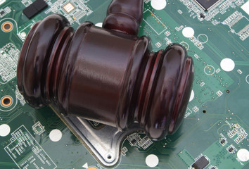 Cyber law and cyber crimes concept, wooden judge gavel on circuit board 