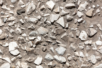 Stone rubble in the concrete wall as background