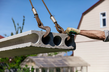 A crane raised a concrete slab at a construction site at home