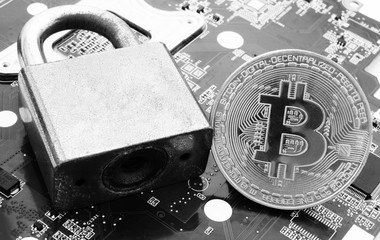 Bitcoins safety concept, bitcoin and padlock on motherboard