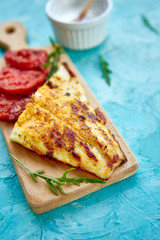 Grilled pike fillet with tomatoes on wooden board