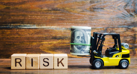 Wooden blocks with the word Risk, money and a forklift. Financial and commercial risk concept. Investing in a business. Risks assessment and management. Credit, loan. Business plan development