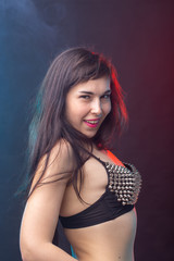 Fototapeta premium Alluring young beautiful brunette woman in a underwear posing on a dark background. Concept of seduction and sexual attractiveness