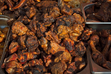 Barbecue fries in the coals. Meat and beef at the field kitchen festival. Fried meat on an iron tray on the table.