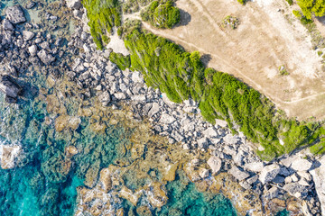 Aerial view of beautiful seashore in summer. Rocky beach and green islands seen from above.