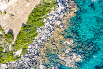 Aerial view of beautiful seashore in summer. Rocky beach and green islands seen from above.