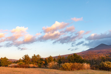 Autumn foliage scenery in Kayano-Kogen plateau, Aomori, Japan. Hakkoda Mountains on background bathed in different hues of red, orange, golden colors. Beautiful landscapes of magnificent fall colours