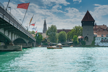 boat on the Rhine river with the historic old town of Constance and Sternenplatz bridge on Lake...
