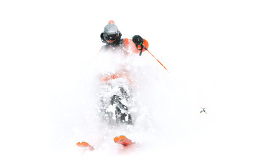 Professional Skier athlete rides out of deep snow while performing a skiing trick in a snowstorm. The winter season is a good powder day. Winter extreme sports