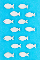 Wooden white fishes on blue background