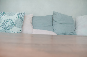 Gray pillow on the bed.On the couch there is a pillow on it.Do not focus on objects.