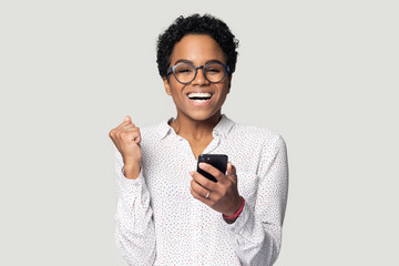 Excited biracial woman feel euphoric reading good news on cellphone