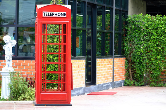 Empty red telephone booth on the footpath