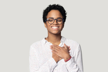 Smiling biracial woman with hands at chest feel thankful