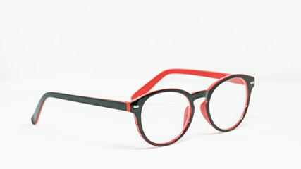Side view of clear red-black glasses placed on a white background
