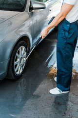 cropped view of man standing near grey modern automobile outside