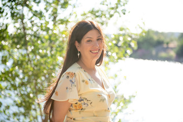 Pretty woman posing in the park by the lake