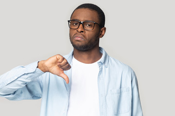 Dissatisfied african American man show thumb down unhappy with service