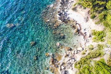 Aerial view of beautiful seashore in summer. Rocky beach and green islands seen from above.