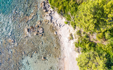 Aerial view of beautiful seashore in summer. Rocky beach and green islands seen from above.