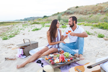 Picnic on the beach at sunset in the style of boho, food and drink conception