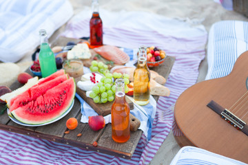 Picnic on the beach at sunset in the style boho, food and drink conception - 279790468