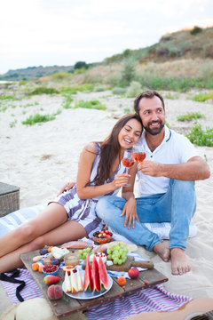 Picnic on the beach at sunset in the style of boho, food and drink conception
