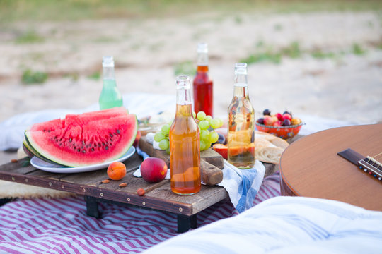 Picnic on the beach at sunset in the style boho, food and drink conception