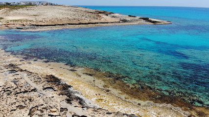 The rocky coast of Cyprus with azure water near Ayia Napa. Flying drone over the sea