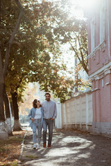 Fototapeta na wymiar Cute couple holding hands walking in street