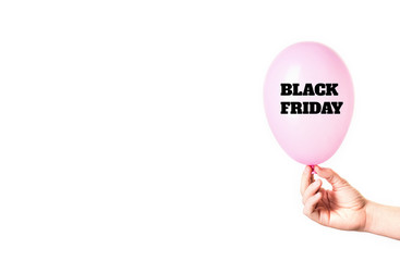 Black Friday inscription on pink balloon in hand isolated on white background.