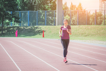 Obraz premium female in sportswear jogging along bridge border while training on stadium outdoors