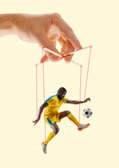 Man like a puppet in somebodies hands on yellow background. Concept of unfair manipulation,...