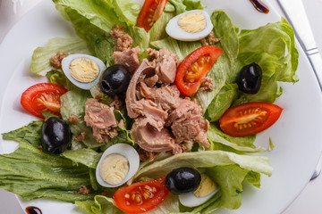 Fresh salad with iceberg lettuce,tomatoes,eggs,canned tuna and olives