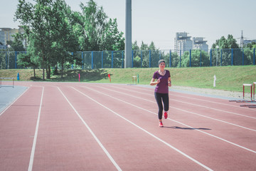Fototapeta premium young fitness woman runner running on stadium track