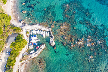 Fototapeta na wymiar Aerial view of small boats at the marina. Beautiful rocky seashore with boats seen from above.