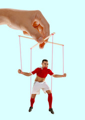 Man like a puppet in somebodies hands on blue background. Concept of unfair manipulation, phycology...