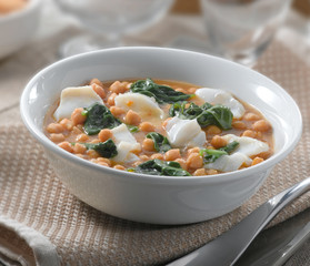Pescado con acelgas y garbanzos sobre mesa. Fish with chard and chickpeas on the table.